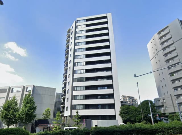 - 高層マンションのファサード、近隣のビルと緑の木々がある街並みの風景