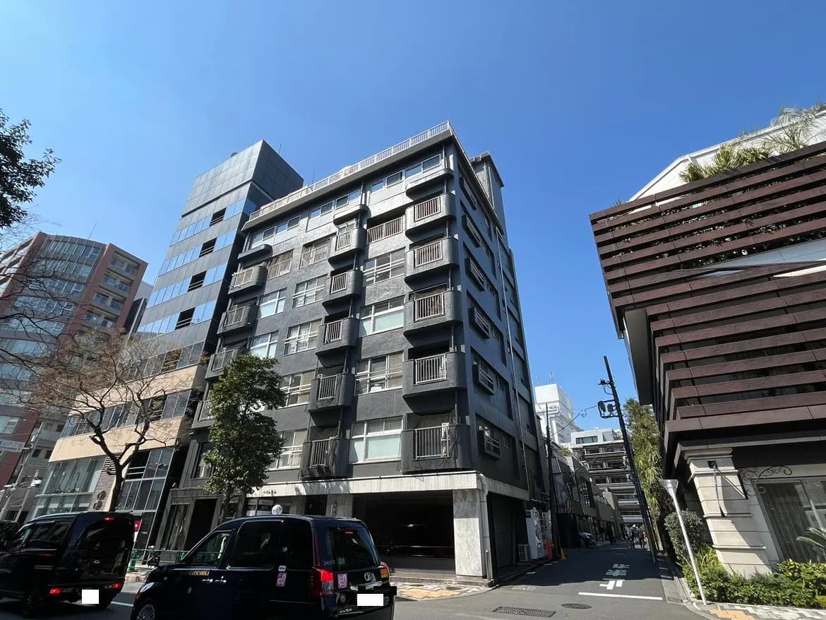 日差しの強い日に撮影された現代的な街並み、複数のオフィスビルとマンションが見える景色