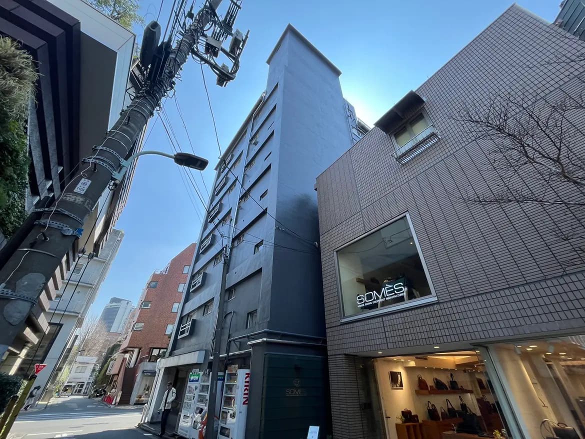 都市の景観として建物、道路、電柱が並ぶ街角の写真