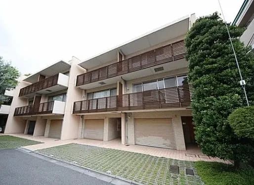 現代的な外観の住宅街にあるアパートのファサード、木製のバルコニーとガレージが特徴