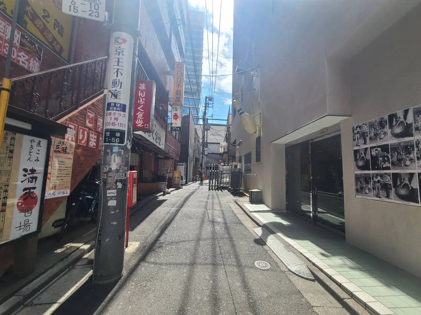 日本の都市の細い路地、日差しが明るい、看板が並ぶ飲食店の外観