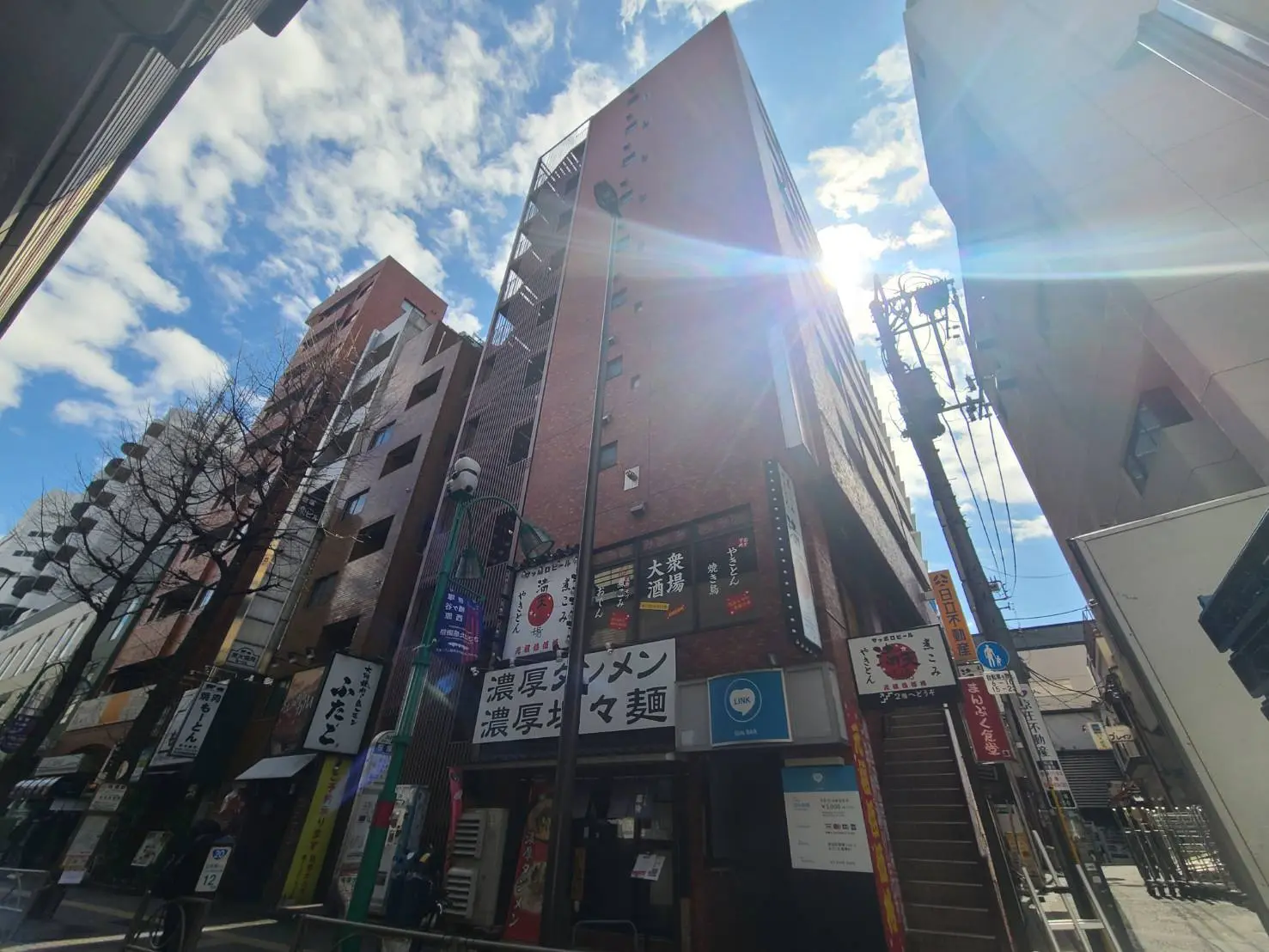 日本の都市の繁華街、レストランと看板の多い通り、晴れた日の青空とビル