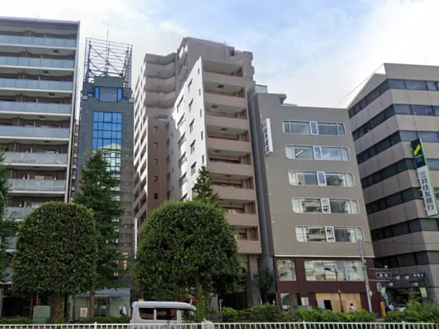 - 都心の高層ビル群と緑豊かな植栽、様々なデザインの建物が立ち並ぶ街並み