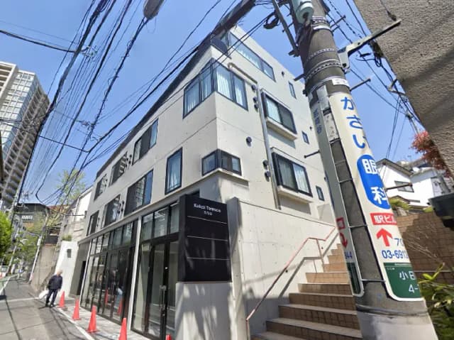 - 現代的なデザインのアパートメント「Kukai Terrace」、コンクリート外観と大きな窓、通りに面したエントランスの風景