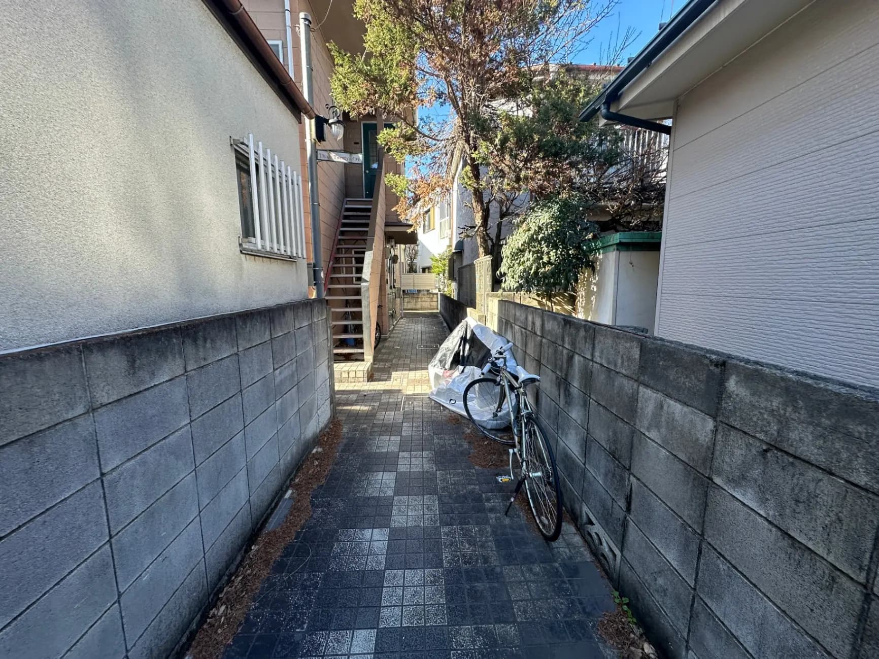 日本の住宅街の狭い路地、駐輪された自転車と階段がある風景