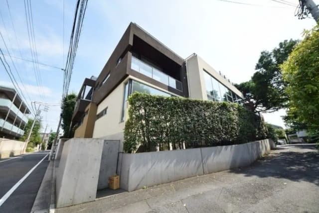 モダンなデザインの都市型住宅、コンクリートの壁とプライベート感を演出する緑豊かな植栽