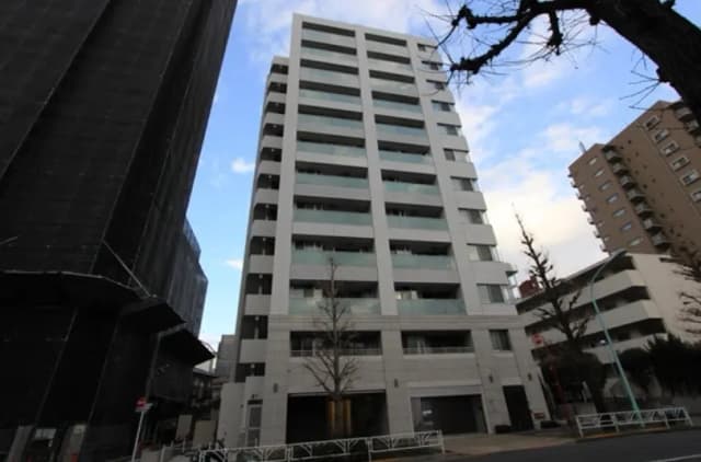 モダンな外観の都市型マンション、空と隣接建物の間に位置、日本の住宅街に建つ