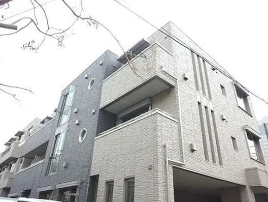 現代的なデザインのマンション外観、白い壁と円形の装飾が特徴的な建築デザイン
