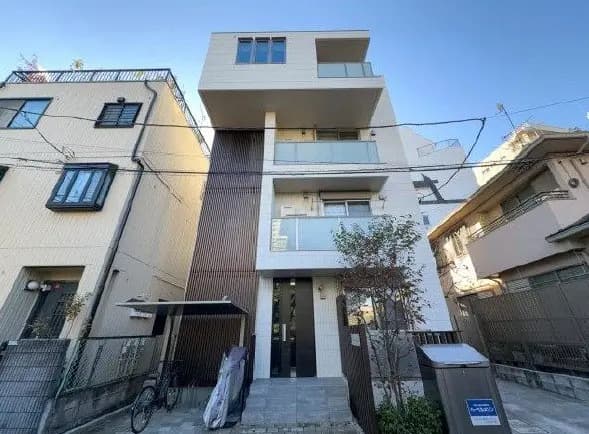 モダンな外観の都市型住宅、明るい色のファサードと木目調のアクセントが特徴的なデザイン