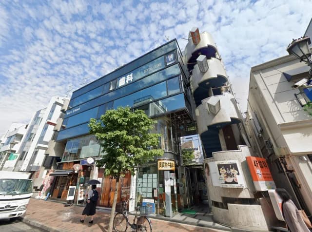 都会の歩行者天国にあるユニークなデザインのビル、店舗とクリニックの看板、快晴の日の街並み