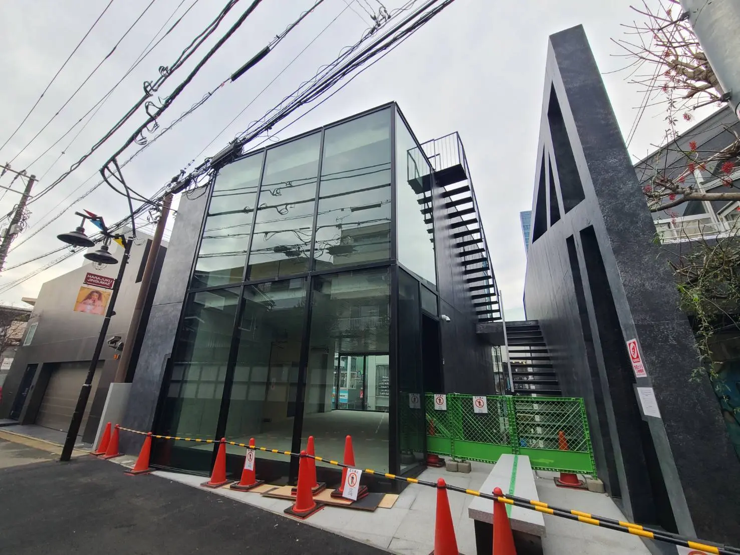モダンでスタイリッシュな外観のビル、ガラス張りの壁と黒い階段、都市の建築デザイン
