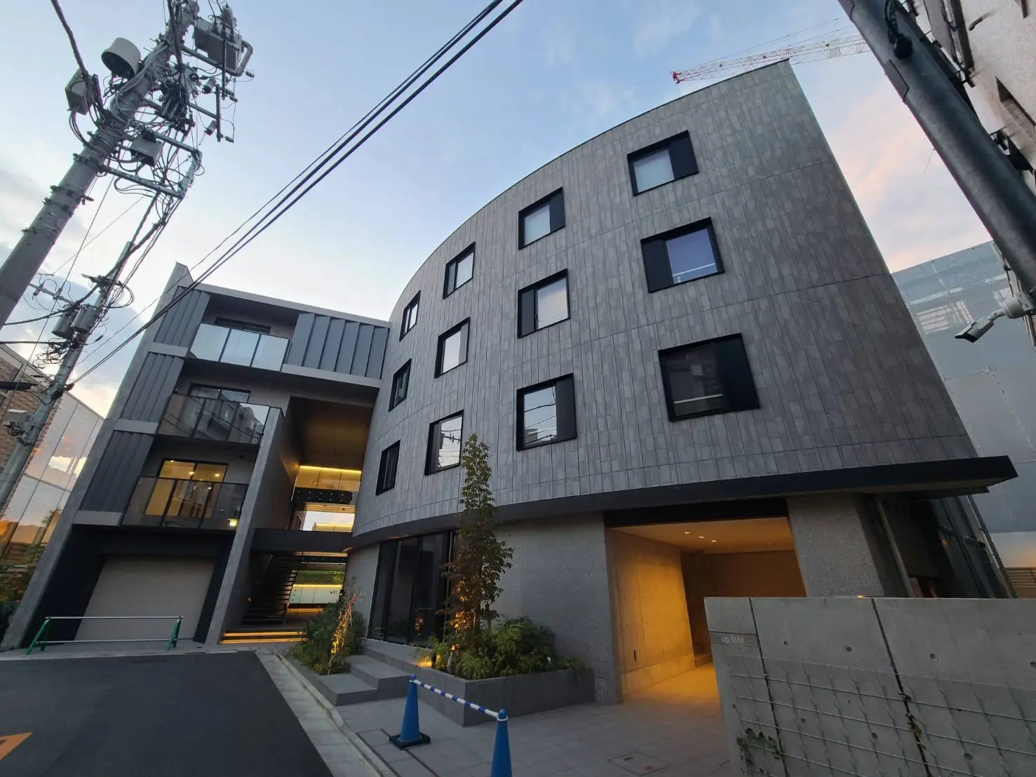 モダンでスタイリッシュな外観の都市型マンション、グレーの外壁と大きなガラス窓が特徴的な建築デザイン