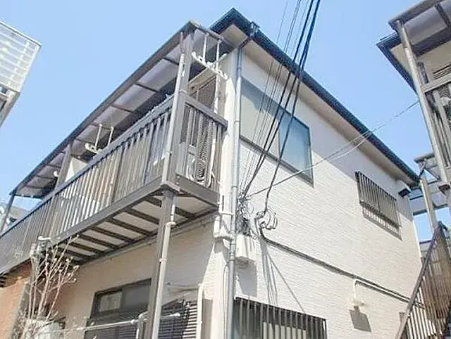 - 外観がシンプルで現代的な二階建て住宅、ベランダと窓が特徴で青空の下にある風景