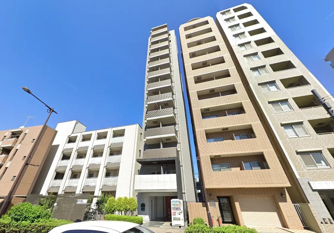 - 青空の下に立ち並ぶ現代的なマンションビル、異なるデザインの外観が特徴的な住宅街の風景