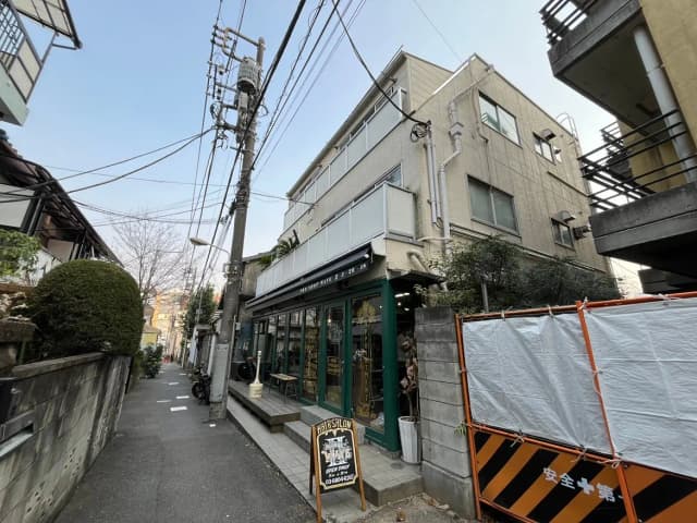 狭い路地にあるおしゃれなヘアサロンの外観、都会の雰囲気が感じられる街角