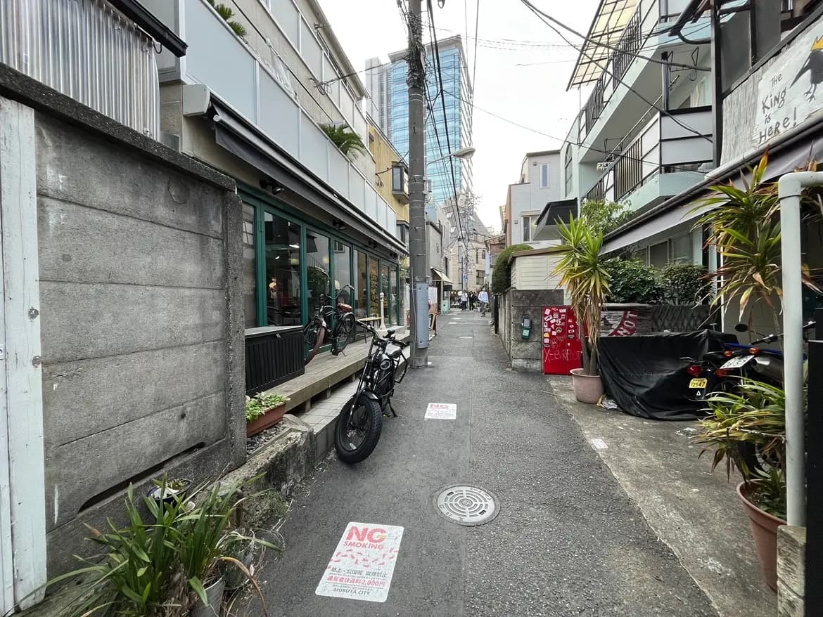 狭い路地と多種多様な建物、自転車とレストランの外観、都市風景
