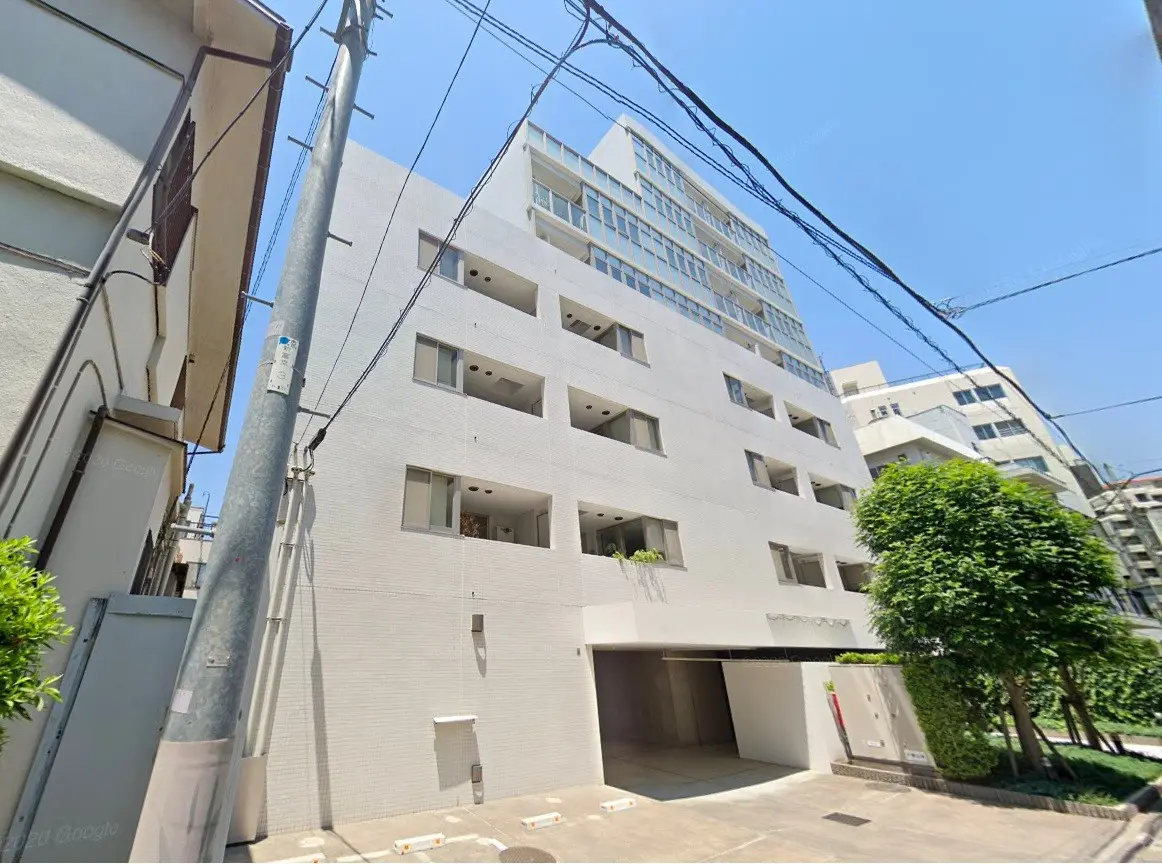 現代的な外観の都市型マンション、白壁とバルコニー、晴れた日の明るい街角