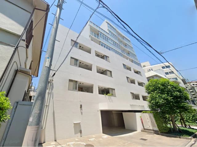 現代的な外観の都市型マンション、白壁とバルコニー、晴れた日の明るい街角