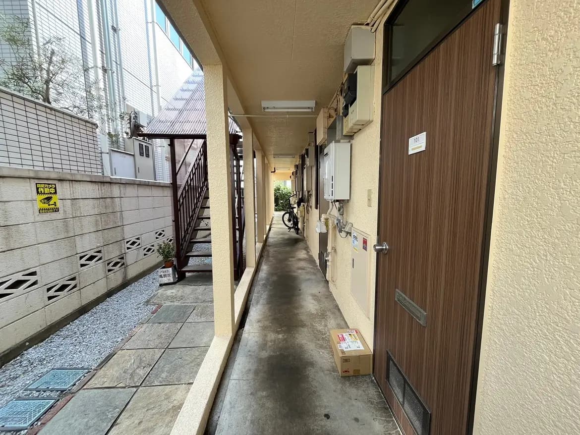 日本の住宅街のアパートの共用廊下、玄関のドアや宅配ボックスが見える外観