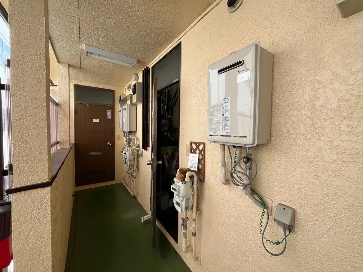 日本のアパートメントの共同廊下、防犯カメラとガスメーター付き