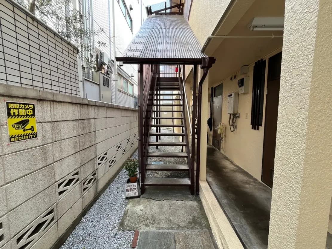 狭い路地と階段、セキュリティステッカー付きの都市住宅街の景観
