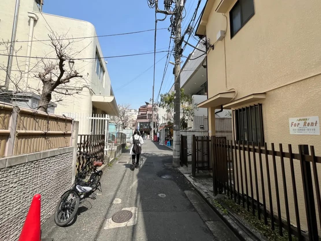 晴れた日の日本の住宅街の風景、徒歩の人々、賃貸物件の看板が見える