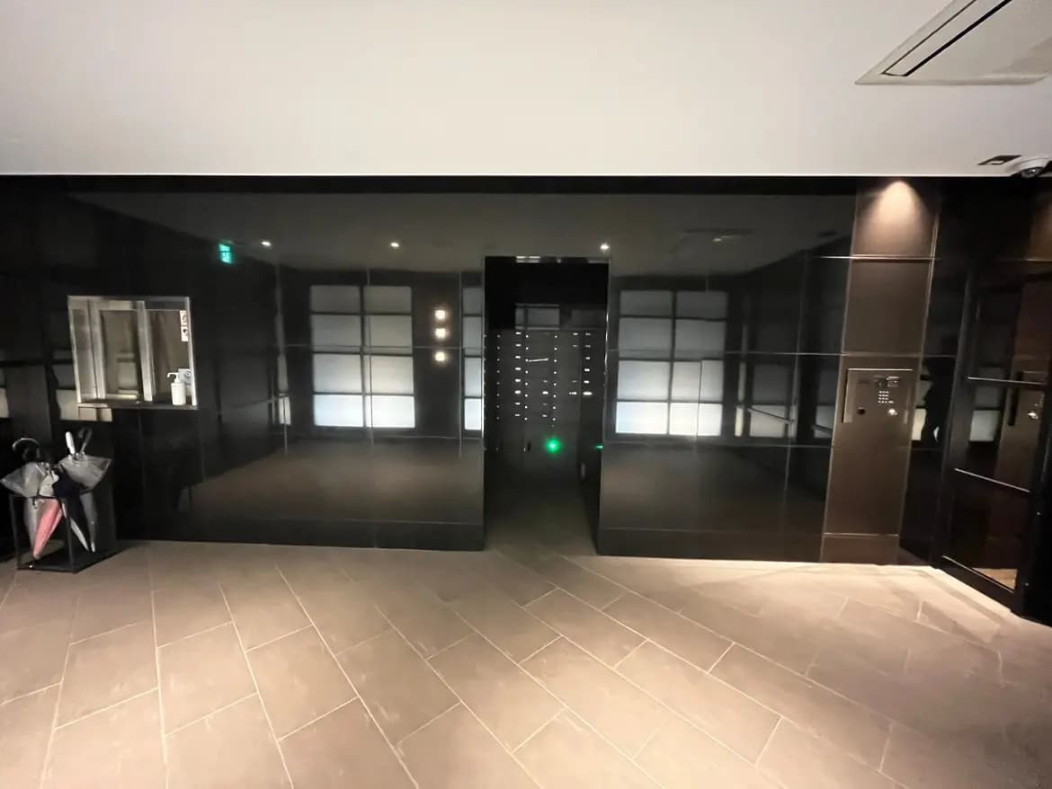 モダンでスタイリッシュなエントランスホール、照明とフロストガラスのドアが特徴的なインテリア