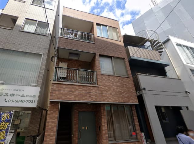 - モダンなデザインのアパートメントビル、レンガ調の外壁、バルコニーと階段、周囲の建物とのコントラストが特徴的な外観