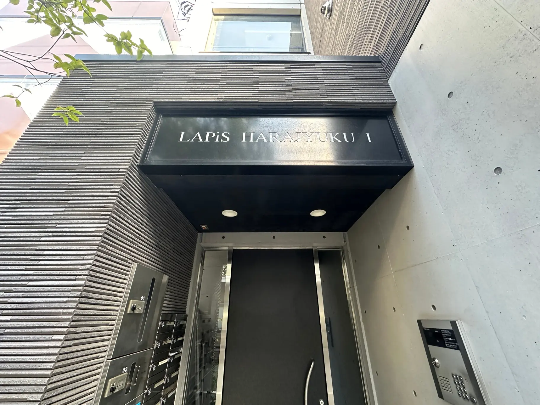 原宿にあるモダンなデザインのビル、LAPIS HARAJUKUのエントリー、黒い壁とスタイリッシュな看板