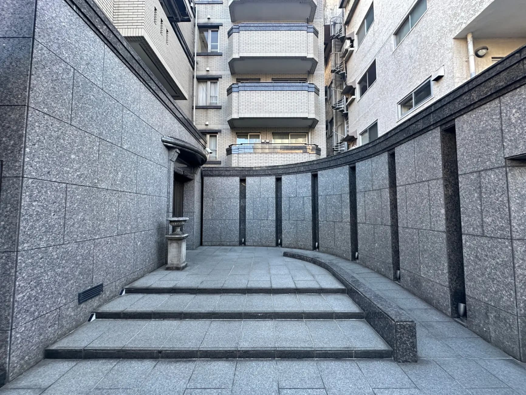 都市風景の中の石造りの建物の間にある中庭、段差のある通路と建物の外壁