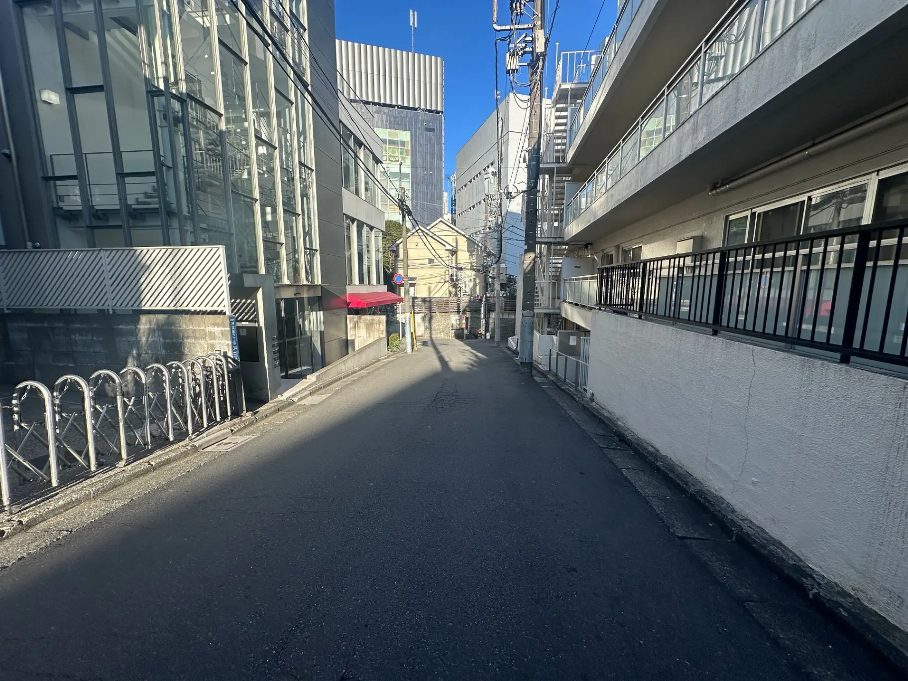 日本の都市部の狭い路地、建物間に光が差し込む景色