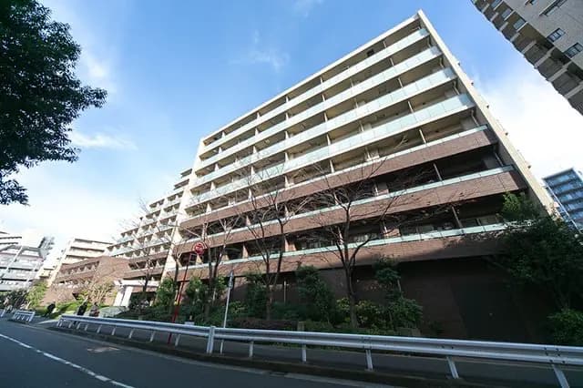 - モダンな集合住宅の外観、自然光を取り入れる大きなバルコニーと緑豊かな周辺環境が特徴の建物
