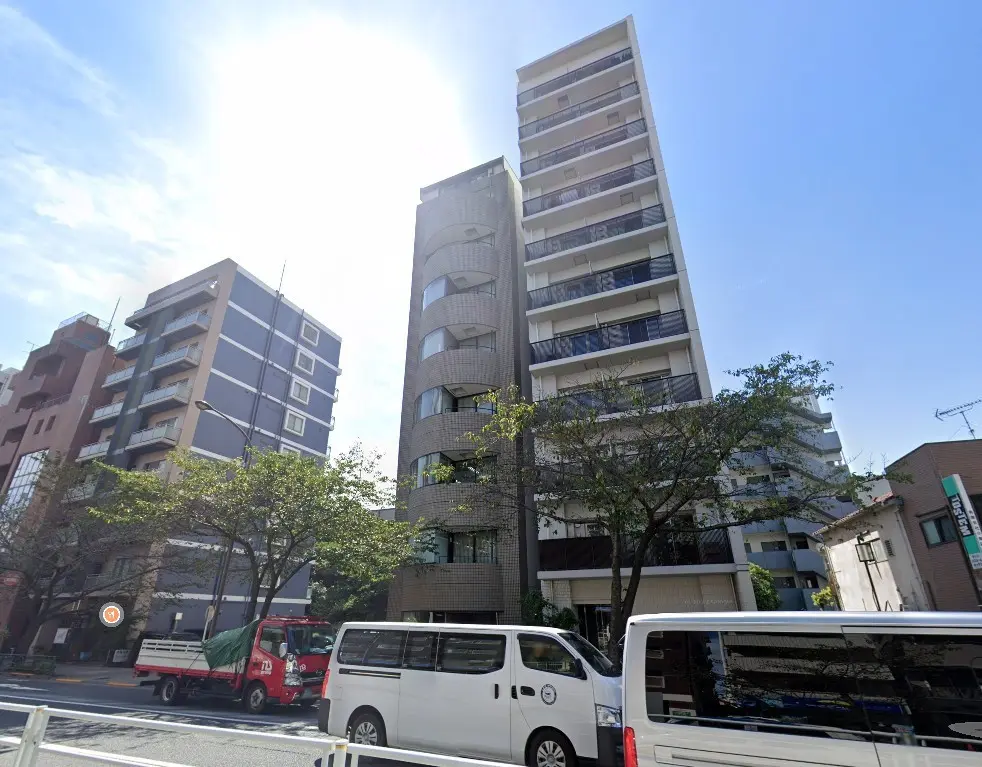 都心の高層マンションと街並み、晴れた日の青空と緑あふれる樹木