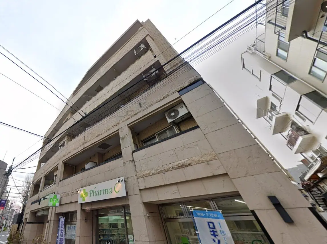 都会の角地に位置する薬局の入った現代的なビルディング、通りに面している店舗