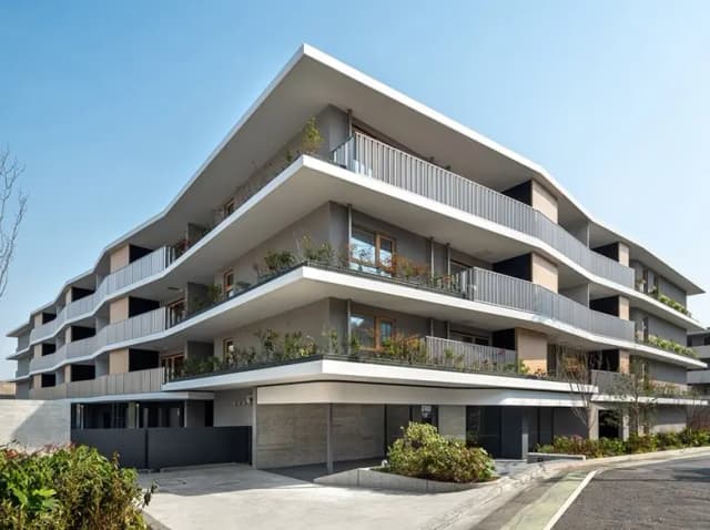 モダンな外観の多階建て住宅、バルコニーに植物があるコンテンポラリーなデザイン