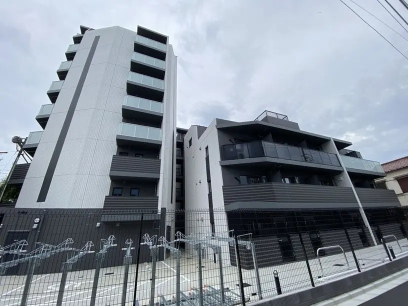 現代的なデザインの新築マンション、グレーで統一された外観、バルコニー付きの複数階建て
