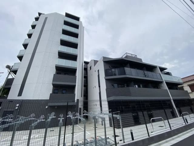 現代的なデザインの新築マンション、グレーで統一された外観、バルコニー付きの複数階建て