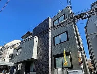 新築そうなモダンな外観の都市型住宅、ブルーの空と都市の電線が見える景色