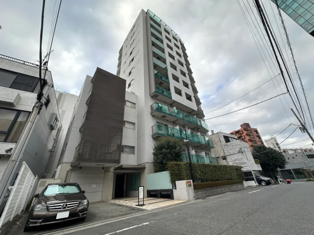 現代的なマンションの外観、街並みと共にメルセデス車が駐車している光景