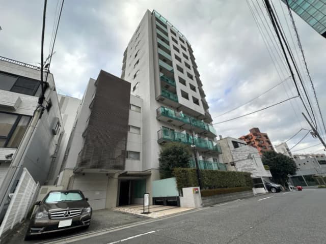 現代的なマンションの外観、街並みと共にメルセデス車が駐車している光景