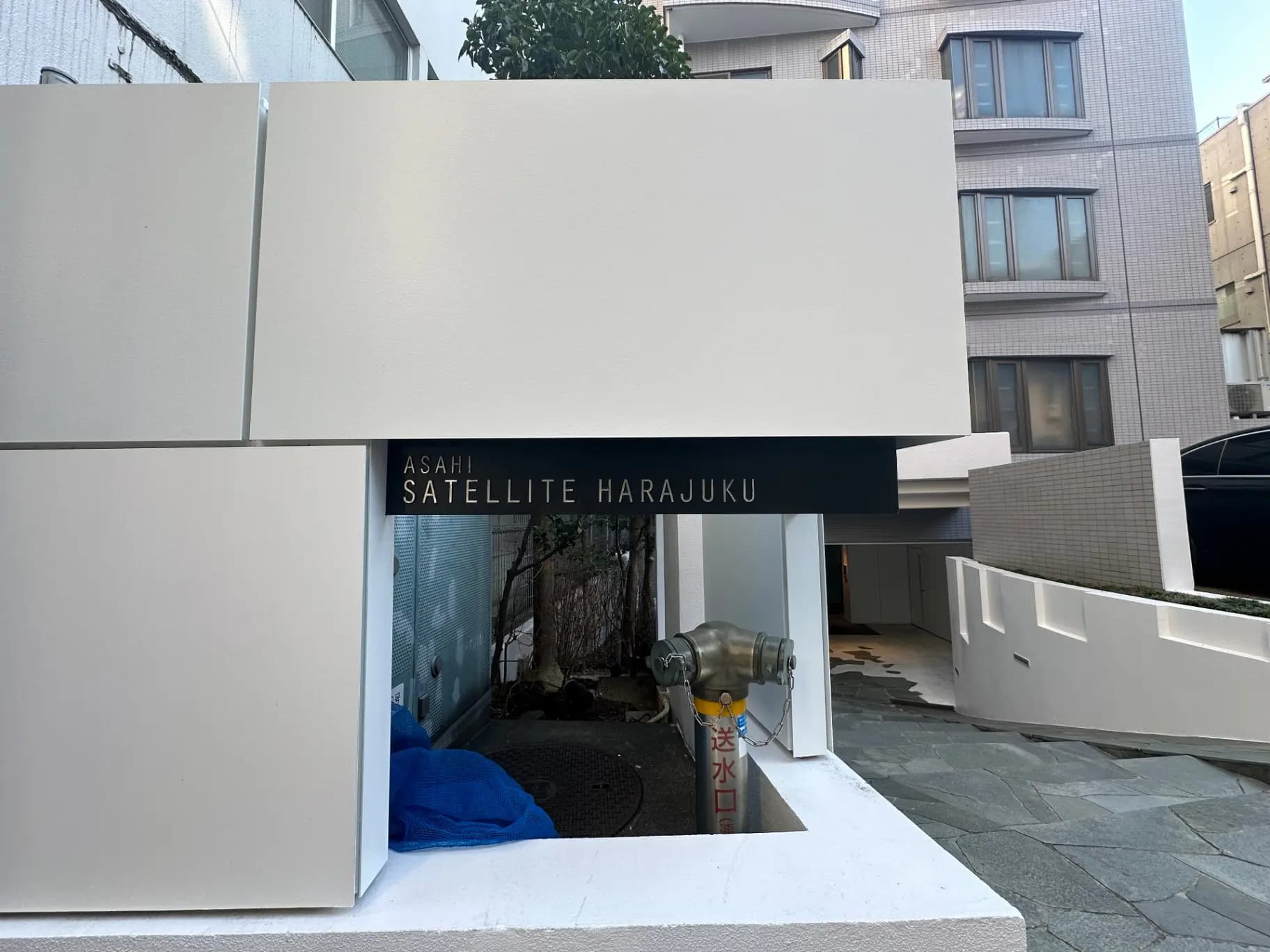 モダンな外観のアサヒサテライト原宿ビル、白と黒のコントラストが際立つ建築デザイン