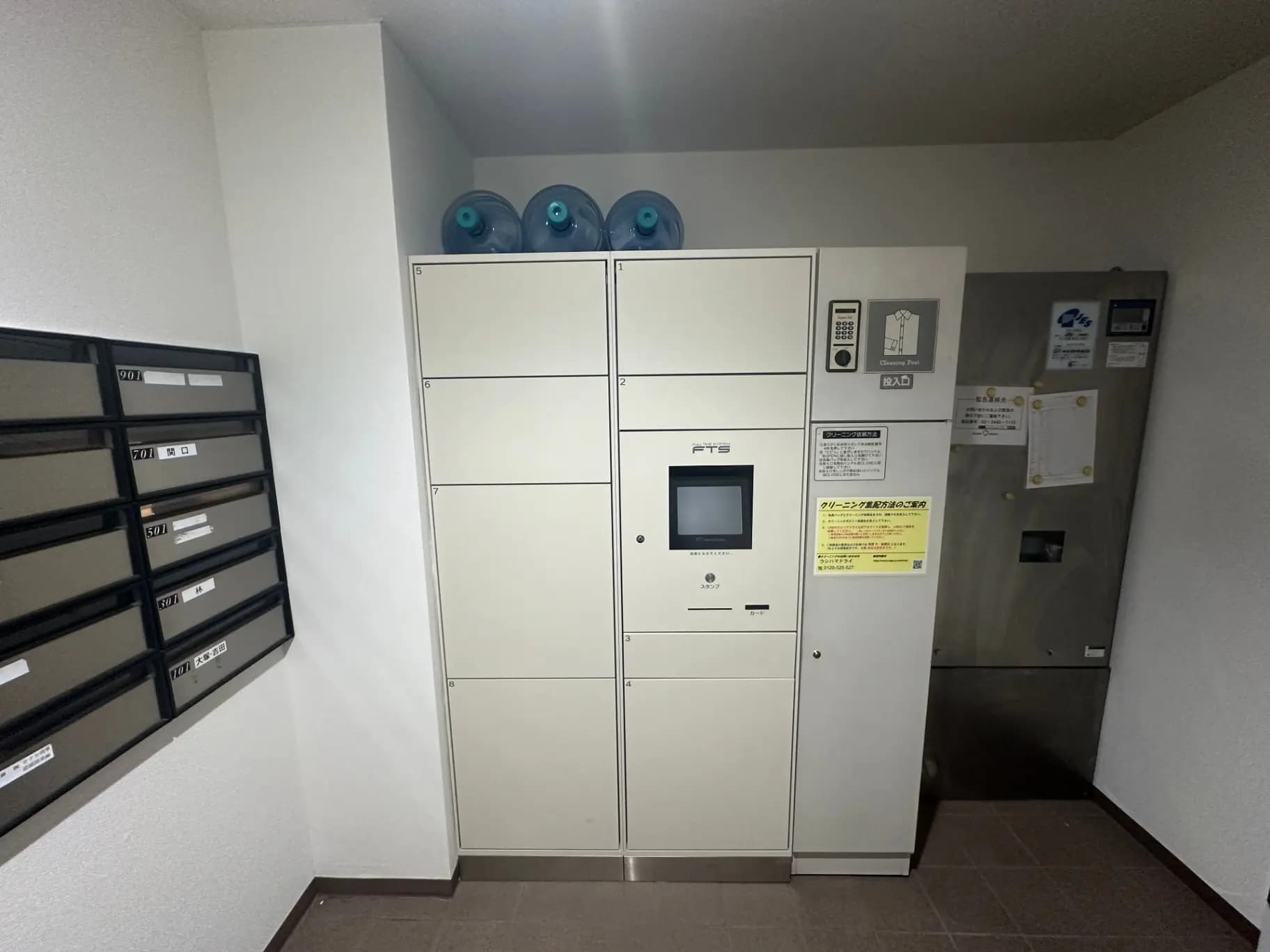 マンションのエントランスホールに設置された宅配ロッカーと郵便ポスト、清潔感のある共有スペース