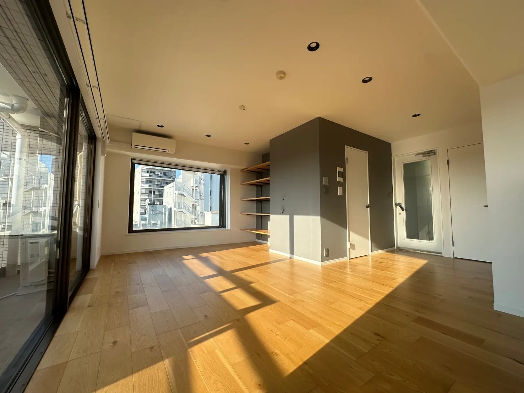 日当たりの良い明るい空間、木目調のフローリング、建築家のためのモダンなデザインのリビングルーム