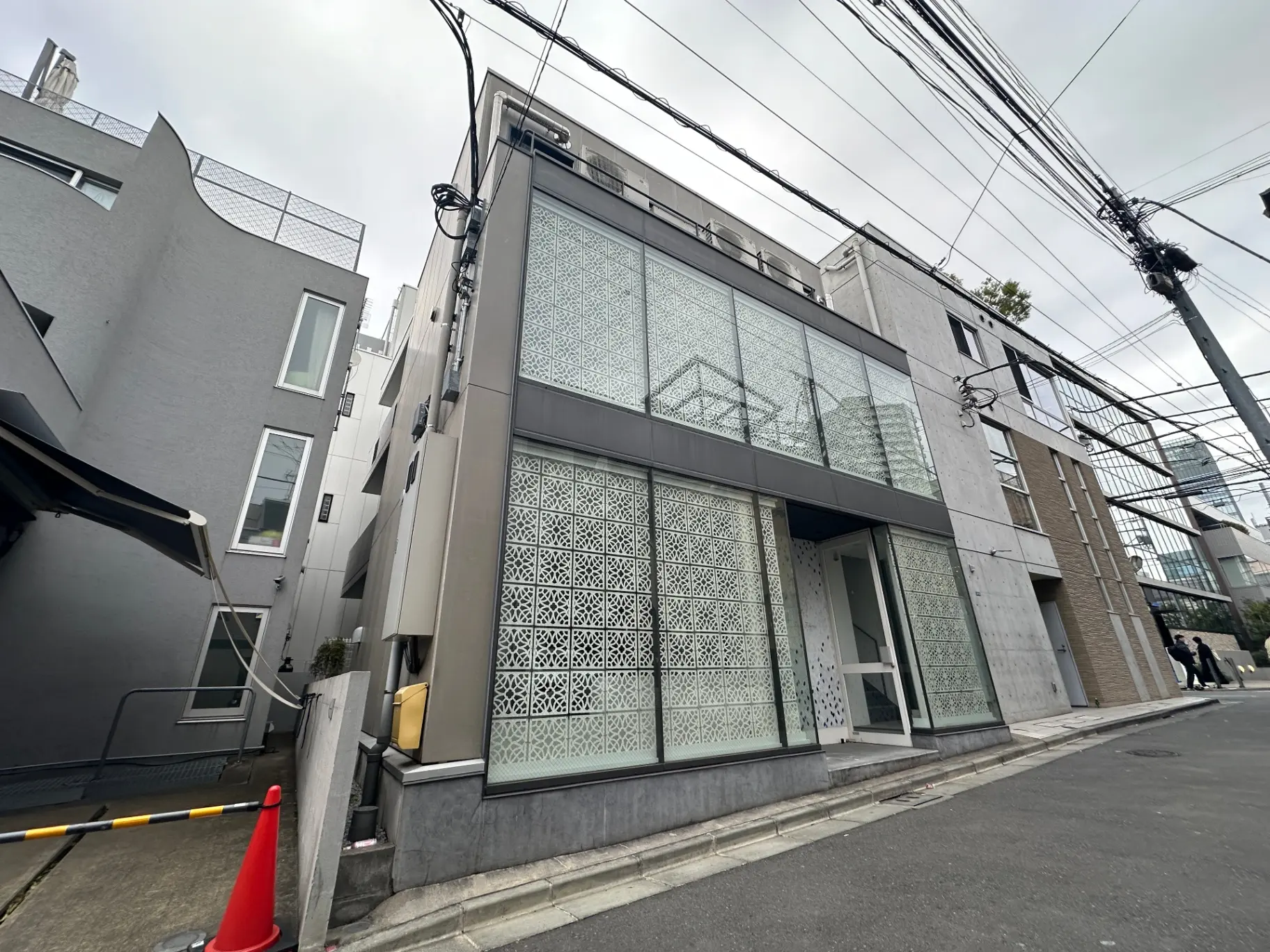 都会的なデザインの外観、ガラス張りのモダンなオフィスビル、都市部の通り沿い