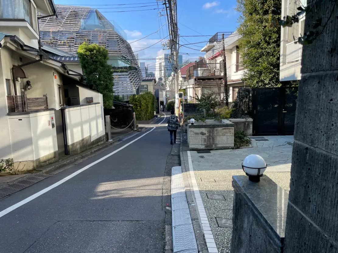 日本の住宅街の道路と歩行者、特徴的な現代建築と晴れた日の風景