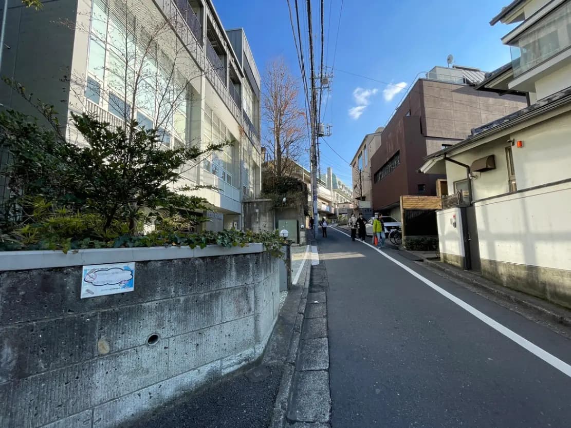 晴れた日の日本の住宅街の風景、歩行者と自転車、青空と建物