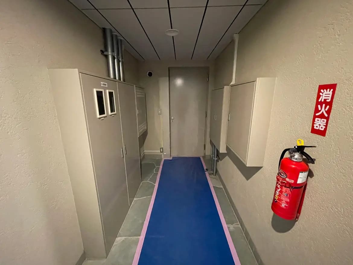 ビルの廊下、非常口の標示と消火器が設置された安全対策が整った通路