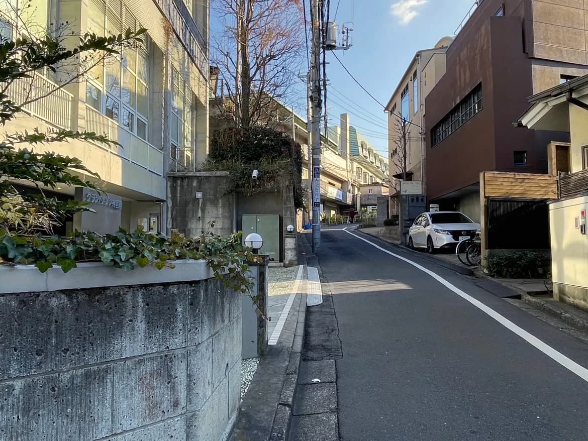 日本の住宅街の風景、コンクリート造りの建物とアスファルトの道路、快晴の日の明るい陽射し