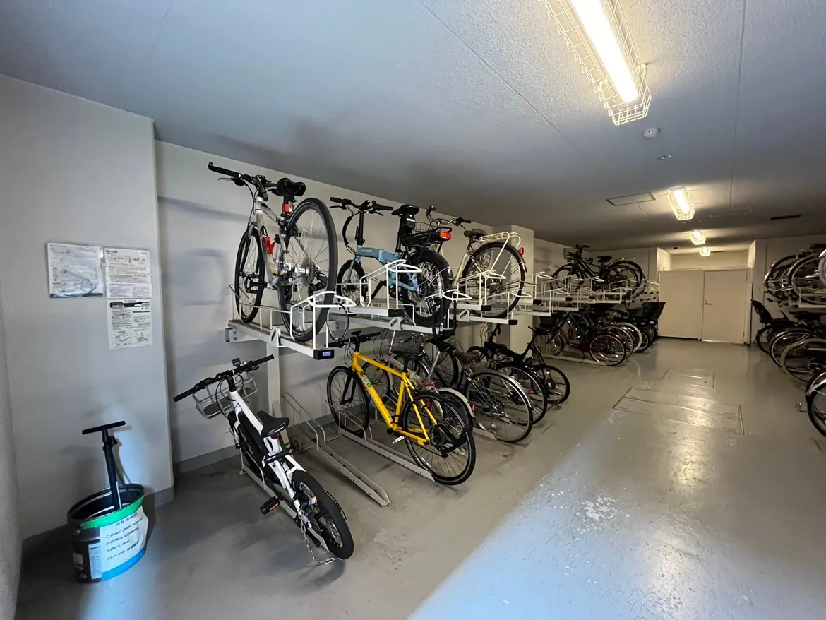 - 自転車置き場の収納スペース、上下に並んだ自転車と明るい照明のインテリア