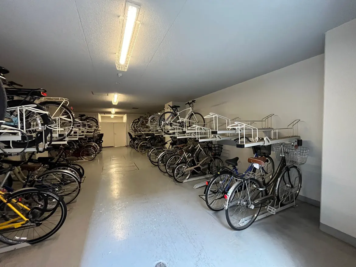 - 自転車が効率的に収納された駐輪場の内部、上下に配置されたラックと明るい照明のある空間